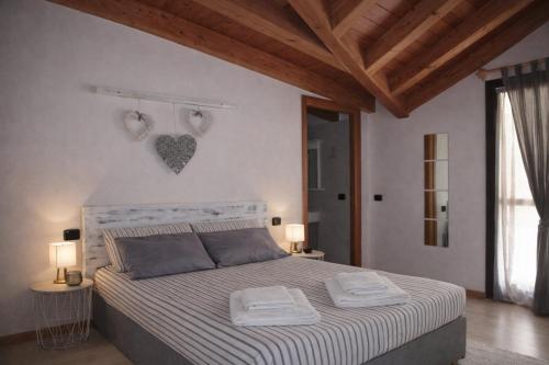 a bedroom with a bed with two towels on it at Albergo Garnì Casa del Lago in Tenno