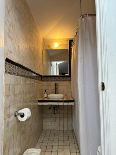 a bathroom with a sink and a toilet and a mirror at Hotel Ciudad Vieja in Guatemala
