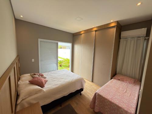 a bedroom with a large bed and a window at Recanto da Bella in Paranapanema