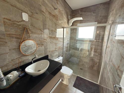 a bathroom with a sink and a toilet and a shower at Recanto da Bella in Paranapanema