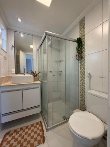 a bathroom with a glass shower and a toilet at Apê mar e descanso com piscina no VOG JOÃO DE GOES ILHÉUS BA in Ilhéus