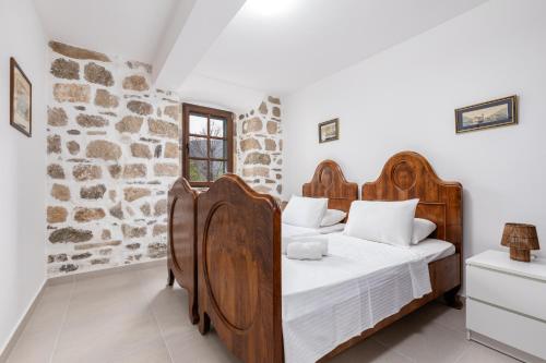 a bedroom with a wooden bed and a stone wall at Casa del Sol in Strp