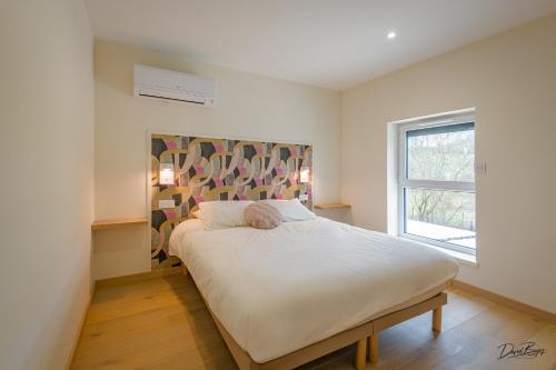 a bedroom with a bed in a room with a window at Domaine de cézille-Appart hotel le Moulin du lac in Jayat