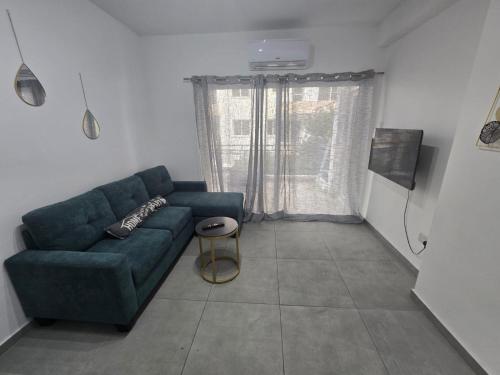 a living room with a green couch and a window at Luxury hideaway in Larnaca