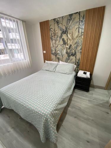 a bedroom with a bed with a checked bedspread at Apartaestudio vacacional in Armenia