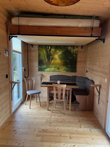 a dining room in a tiny house with a table and chairs at Tinyhaus auf dem Forsthof in Trinwillershagen