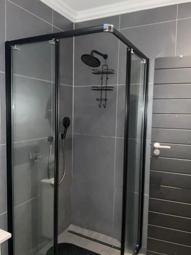 a shower with a glass door in a bathroom at Almond Place in Tokai