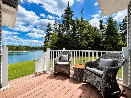 a deck with chairs and a view of the water at Oceanfront Cottage on Private Island in Milbridge