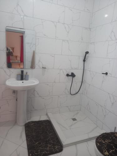 a white bathroom with a sink and a shower at Casa Pirinha in Portela