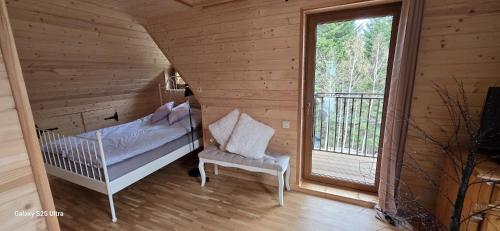 a bedroom with a bed and a chair and a window at Sarnia CHATA in Brenna