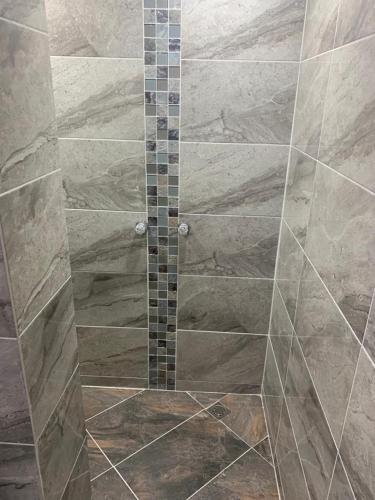 a shower with a glass door in a bathroom at Apartahotel El Horizonte in Guatapé