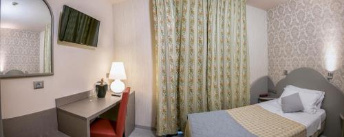 a hotel room with a bed and a desk and a mirror at Marchi Hotel in Soliera