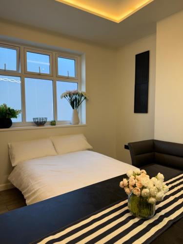a bedroom with a bed and a couch and windows at The Party Hub in Boston