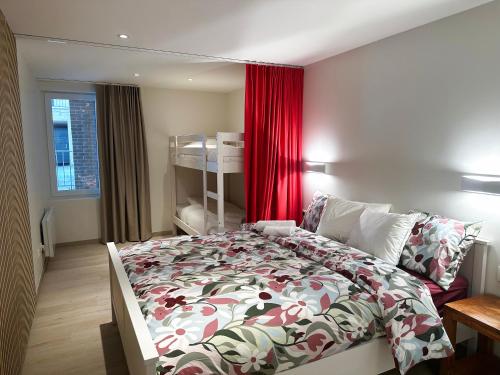 a bedroom with a bed and a red curtain at Art Donna met zeezicht in Middelkerke