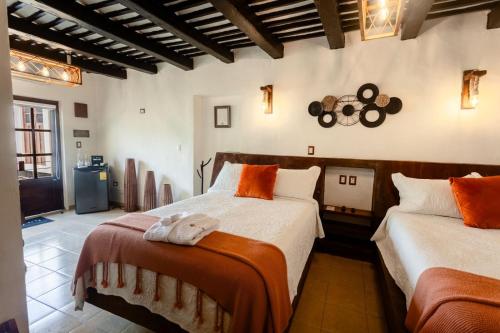 ein Schlafzimmer mit zwei Betten und einer Uhr an der Wand in der Unterkunft Kuxtal Hotel Boutique in Mérida