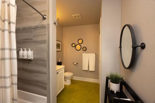 a bathroom with a shower with a toilet and a mirror at 3rd Street Flats in McMinnville