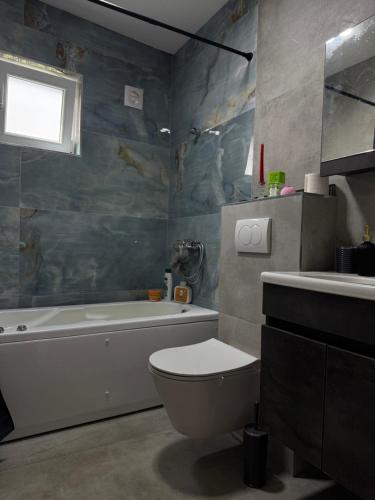a bathroom with a tub and a toilet and a sink at Peja Riverside Hostel in Peje