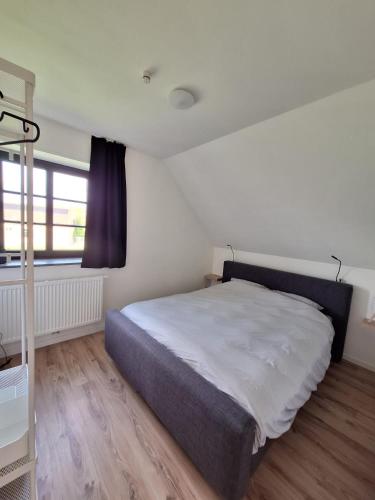 a bedroom with a large bed and a window at 't Ooievaarszicht in Veurne