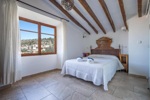 a bedroom with a bed in a room with a window at Hostal Miramar in Deia