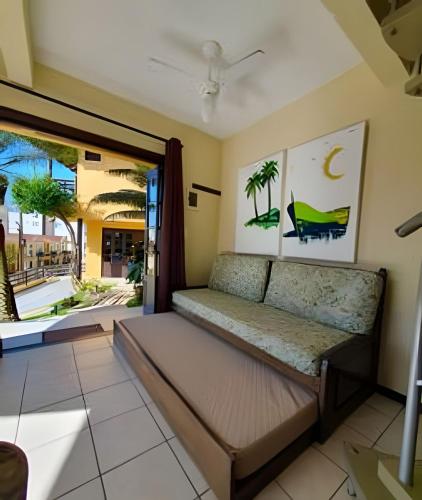 a bed in a room with a window at Villa Garoupeta in Bombinhas