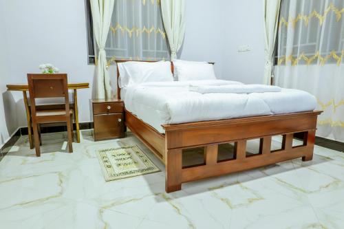 a bedroom with a bed and a desk and a chair at Cozycore Apartment in Dodoma