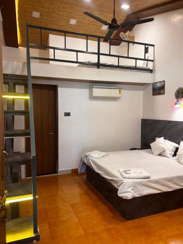 a bedroom with a bunk bed with a ceiling fan at Velkar Cottage Mahabaleshwar in Mahabaleshwar