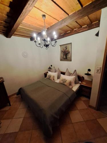 a bedroom with a bed and a chandelier at Kasza Rusztika in Szekszárd