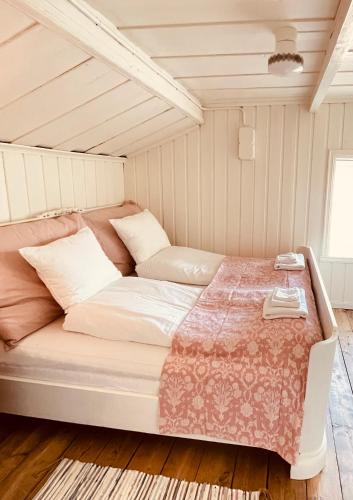 a large bed in a room with white walls at Pålberget in Råkvåg
