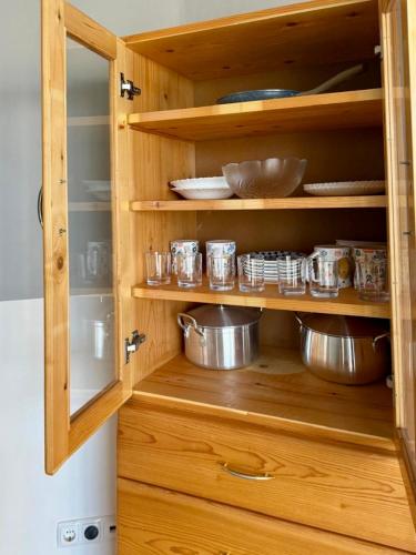 a wooden cabinet with pots and pans in it at Ponta Preta Village 9 in Vila do Porto