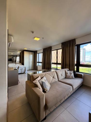 a living room with a couch and a bedroom at Heron Marinho Comfort Flat in Campina Grande