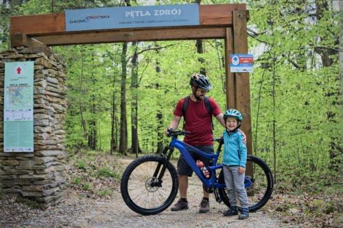a man and a boy with a bike at a sign at Apartament ZłotogórSKI Lądek-Zdrój in Lądek-Zdrój
