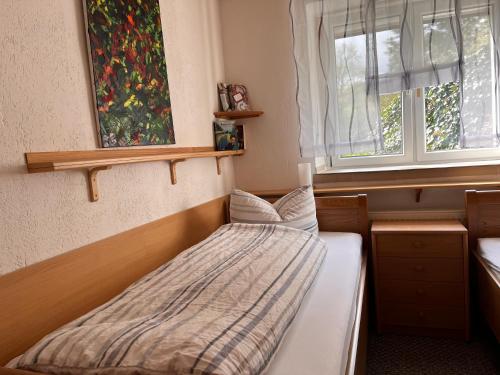 a small bedroom with a bed and a window at Haus Talruhe in Kurort Altenberg
