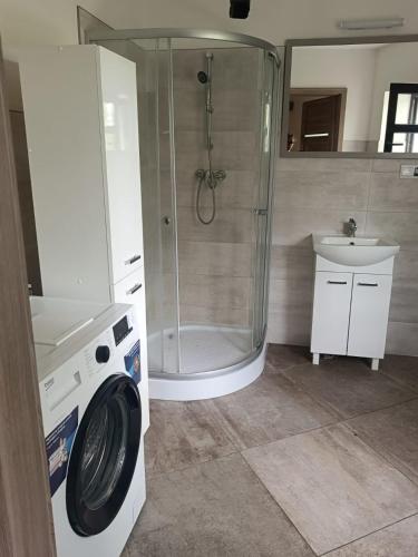 a bathroom with a shower and a washing machine at OLD TOWN Olsztyn in Olsztyn