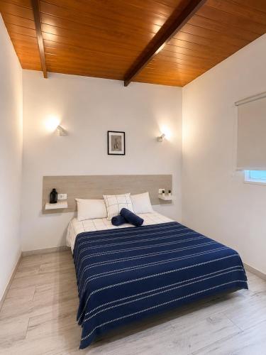 a bedroom with a bed with a blue and white striped blanket at Casa Rural Encantadora Con Terraza Privada in Arona