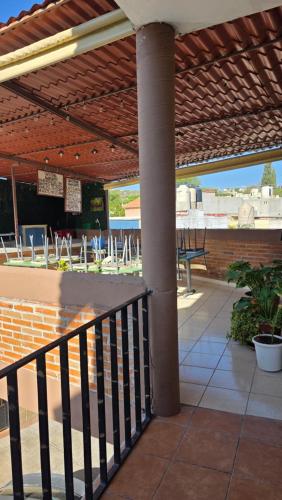 a patio with a fence and tables and chairs at Hotel Villas Kerendarhú in Bernal