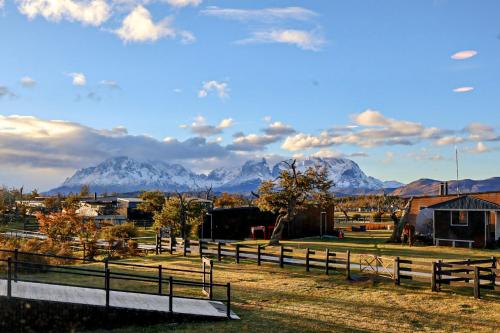a fence in a field with mountains in the background at Geikie Lodge in Torres del Paine
