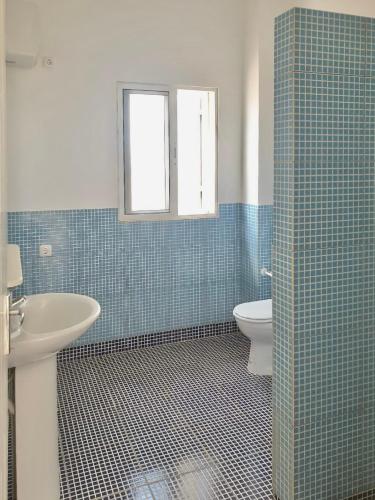 a bathroom with a toilet and a sink and a window at Ponta Preta Village 10 in Vila do Porto