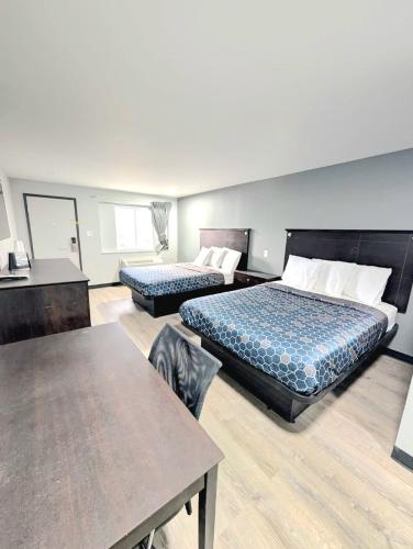 a hotel room with two beds and a table at BlissPoint Inn Muncie in Muncie