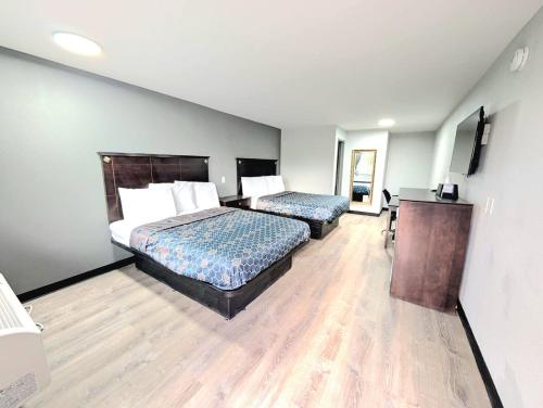 a hotel room with two beds and a desk at BlissPoint Inn Muncie in Muncie
