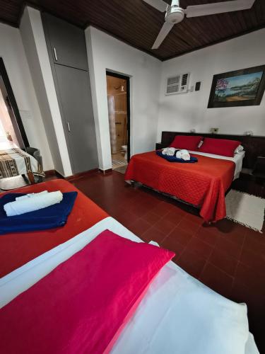 dwa łóżka w pokoju z czerwono-białym w obiekcie Hotel Residencial Marlis w mieście Posadas