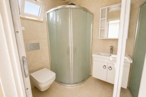 a bathroom with a shower and a toilet and a sink at Villa Sena in Dalyan