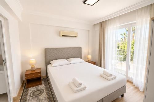 a white bedroom with a bed and a window at Villa Sena in Dalyan
