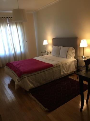 a bedroom with a bed with two tables and two lamps at Apartamento Senadomum in Seia