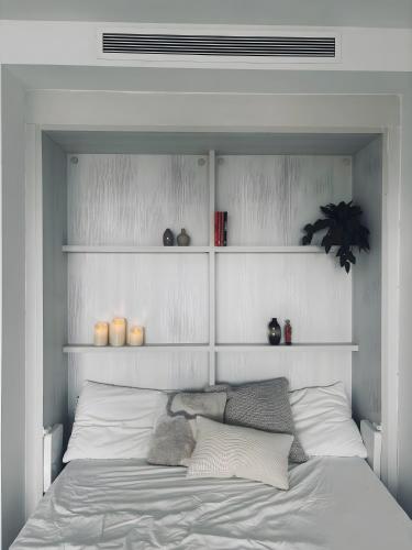 a bedroom with a bed with white walls and shelves at Casa Pedro Santa Clara in Torremolinos