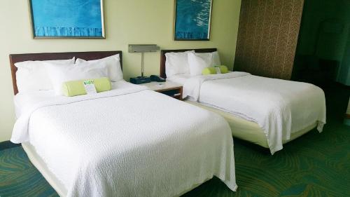a hotel room with two beds with white sheets at SpringHill Suites Pittsburgh Monroeville in Monroeville