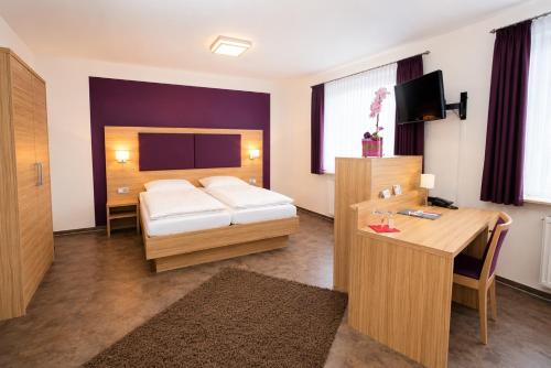 a hotel room with a bed and a desk at Hotel Pale Wolfsburg 24H Self Check-in in Wolfsburg