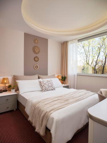 a bedroom with a large white bed with a window at İS Hotel in Antalya