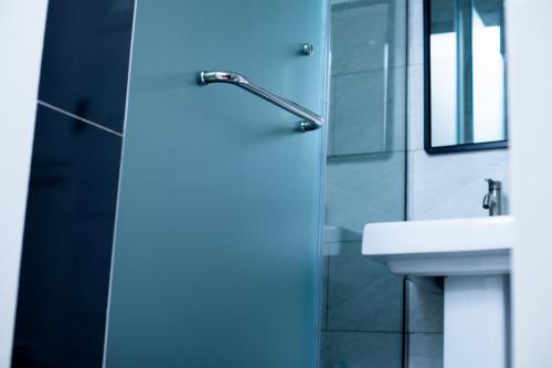 a bathroom with a glass shower door next to a sink at Travellers Palace Hotel in Kampala
