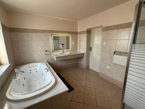 a large bathroom with a tub and a sink at Willa Rudno Nad Jeziorem in Rudno