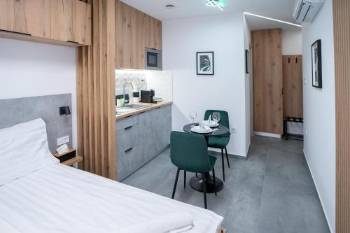 a bedroom with a bed and a table and a kitchen at AApartman Prime in Pécs